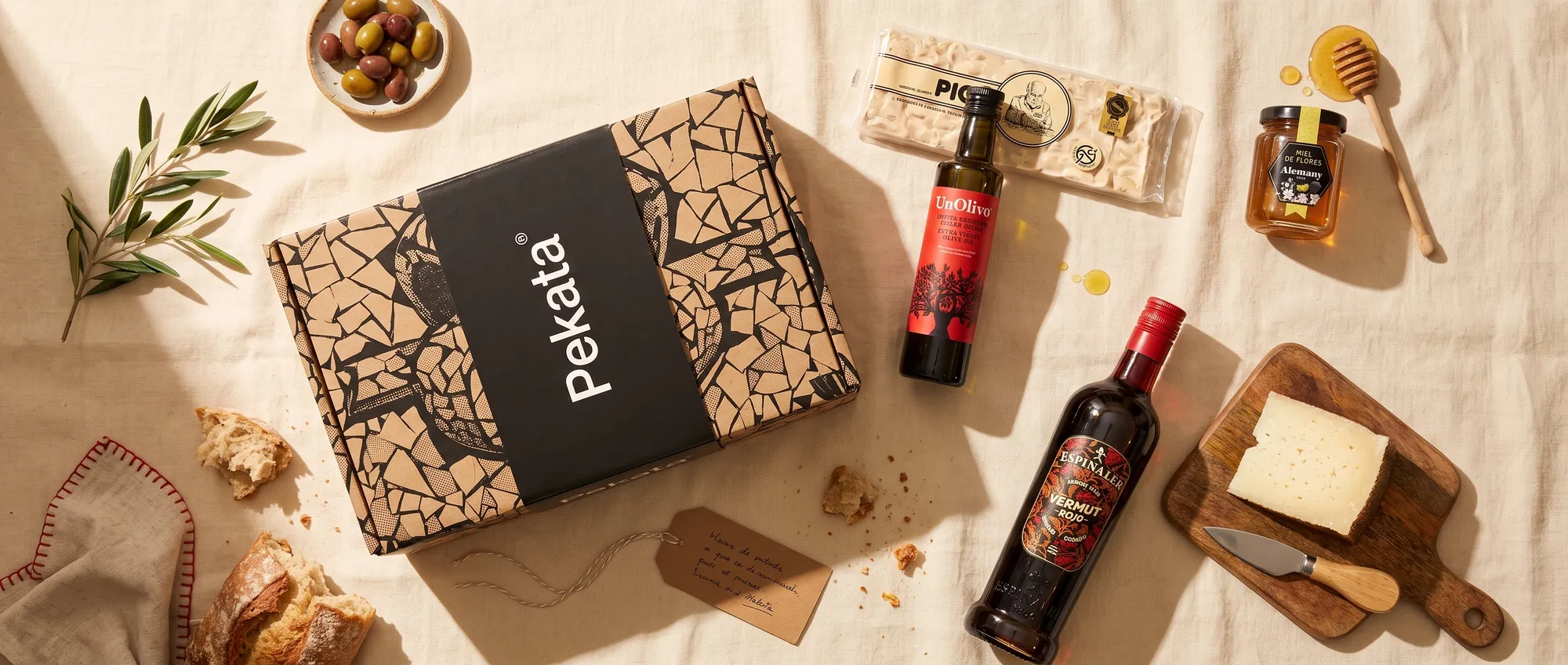 Pekata Christmas hamper box with artisan turrón, honey, olive oil and vermouth on a table